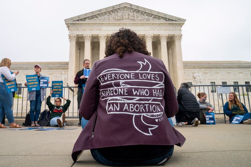 A pro-choice activist wears a jacket that reads: Everyone loves someone who has had an abortion. EPA