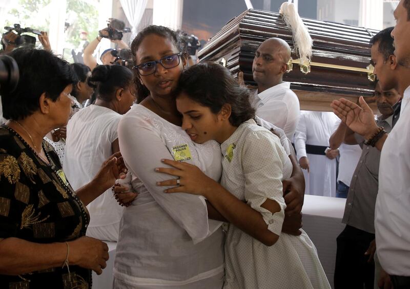 People react near a casket. Reuters