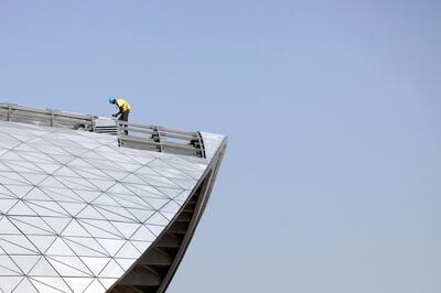 Abu Dhabi, UAE - March 15, 2010 - A laborer works on the roof of the library of the Masdar Institute of Science and Technology at Masdar City. The city plans to rely entirely on solar energy and other renewable energy sources, with a sustainable, zero-carbon, zero-waste ecology. (Nicole Hill / The National