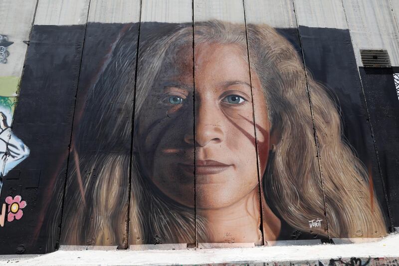 epa06917211 A view of a mural depicting Ahed Tamimi, a 17-year-old Palestinian campaigner against Israel's occupation, on the Israeli separation wall in the West Bank city of Bethlehem, 29 July 2018. Ahed Tamimi, who was arrested last December after she was filmed slapping an Israeli soldier near Ramallah, in the occupied West Bank, was released from prison on 29 July 2018 after serving nearly eight-month in detention.  EPA/ABIR SULTAN