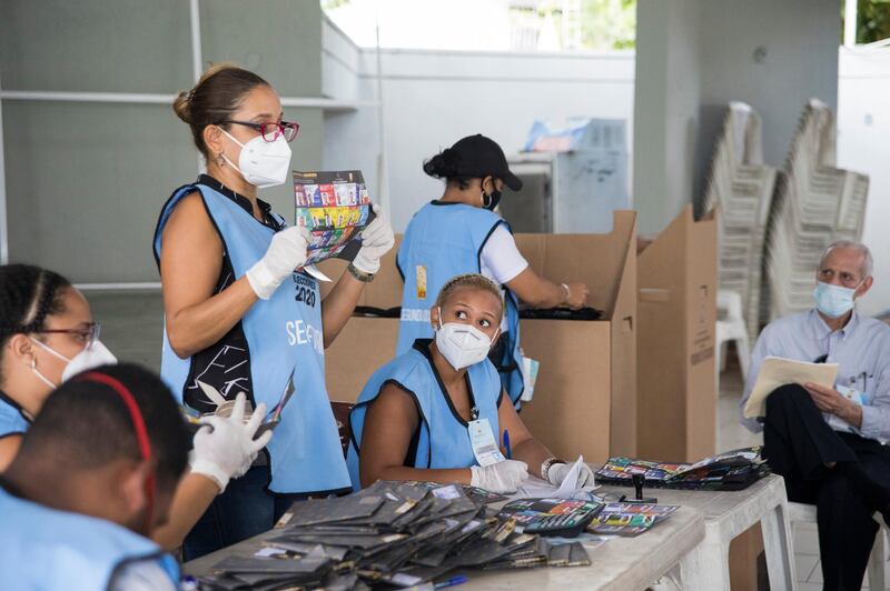 Electoral officials wear protective masks as a precaution against the spread of the new coronavirus, count ballots after polls closed during the presidential elections, in Santo Domingo, Dominican Republic. AP Photo