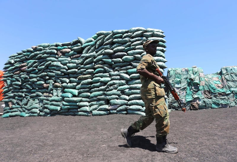 FILE PHOTO: A Somalian soldier walks past a consignment of charcoal destined for the export market in Barawe October 12, 2014.  REUTERS/Feisal Omar  (SOMALIA)/File Photo