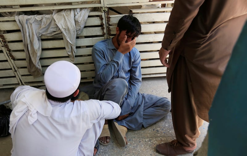 An Afghan mourns the death of his brother, who was one of the health workers shot and killed in Jalalabad. Photo: Reuters