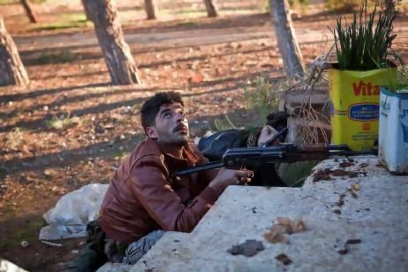 A Free Syrian Army fighter checks for a jet during an operation to take control of the sprawling Al Mosthat military base at the own of Tal Sheen in the Aleppo province.