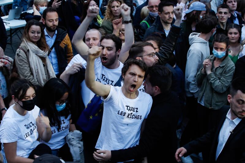 Activists wearing T-shirts reading ‘tax the rich’ interrupt a speech by Mr Macron at a campaign event in Strasbourg. EPA