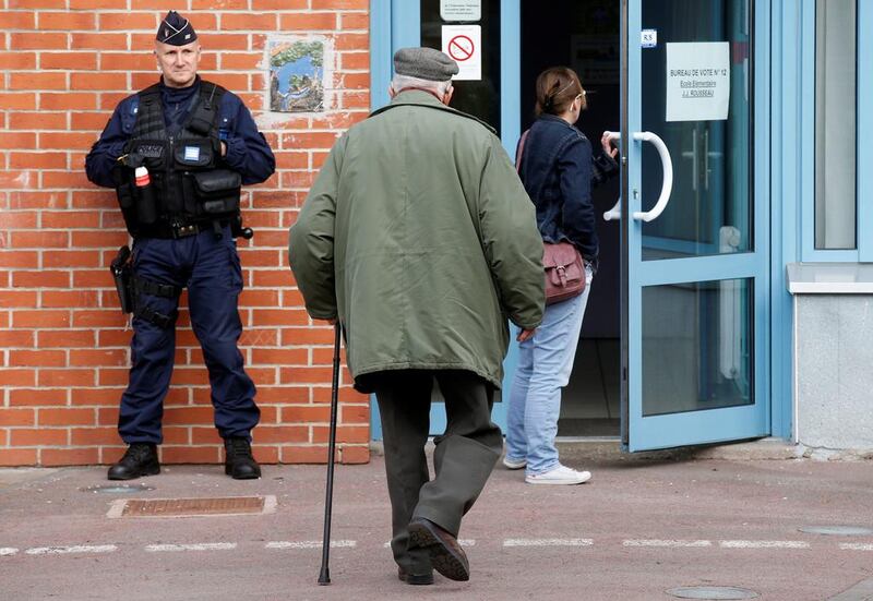 A policeman securing the entrance of a polling station as people arrive to vote in Henin-Beaumont, France. Pascal Rossignol/Reuters
