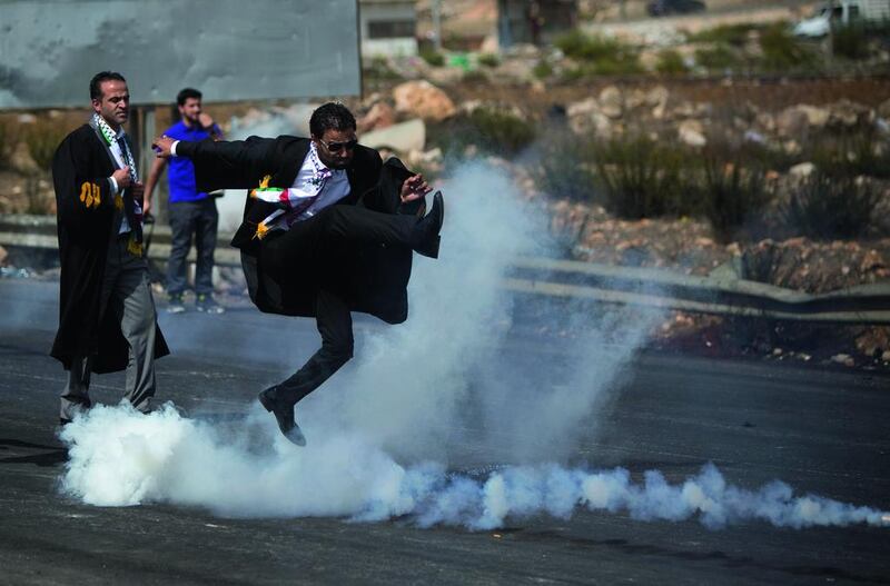 A lawyer wearing his official robes kicks a tear gas canister back toward Israeli soldiers during a demonstration by Palestinian lawyers in solidarity with protesters at the Al Aqsa mosque compound in Jerusalem's Old City. Majdi Mohammed / AP Photo