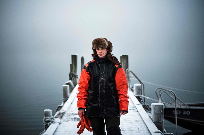Lotta Klemming, a professional oyster diver, poses for photos after a dive at the quay near her family's company in Grebbestad in Vastra Gotaland county on Sweden's west coast on January 31, 2021.  Klemming left a career in the fashion industry in Sweden to return to her family’s home, taking up diving for wild oysters as a business, selling the distinctive-flavored seafood to restaurants  around Sweden and enjoying the feeling of being close to nature in the area where she grew up. - TO GO WITH AFP STORY BY TOM LITTLE
 / AFP / Jonathan NACKSTRAND / TO GO WITH AFP STORY BY TOM LITTLE
