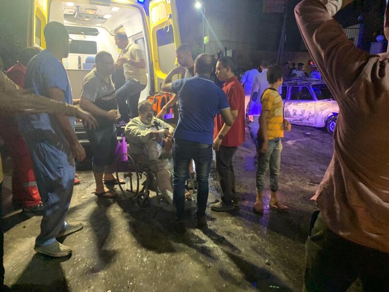 People tend to an injured man after a blast outside the National Cancer Institute, Cairo, Egypt. EPA