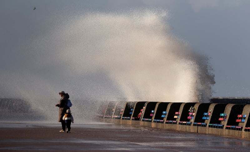 Waves break over the sea wall in strong winds at New Brighton. Reuters