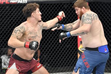 Tom Aspinall, left, of England punches Jake Collier in their heavyweight fight during the UFC Fight Night on July 26 in Abu Dhabi. Zuffa LLC / Getty