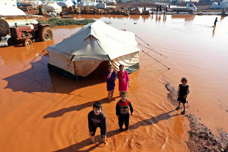 Children standing outside a tent at the flooded Mukhayyam Al Khair camp near the village of Kafr Uruq in the north of Idlib province. AFP