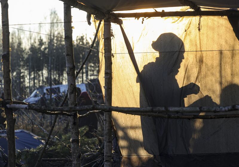 A migrant builds a tent in the camp at the Belarus-Polish border. EPA