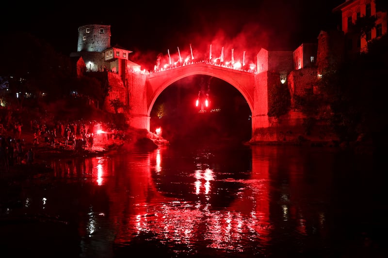 A diver holding torches jumps from the Old Bridge during a night show, part of the 456th annual high-diving competition in Mostar, Bosnia. AP