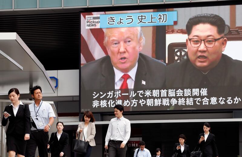 Pedestrians walk past a large screen displaying US President Donald Trump and North Korean leader Kim Jong Un in Tokyo. Franck Robichon / EPA