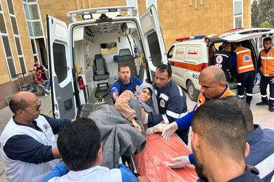 Medics transport a wounded Palestinian out of an ambulance at the Rafah border crossing in Egypt after being evacuated from the Gaza Strip. AFP