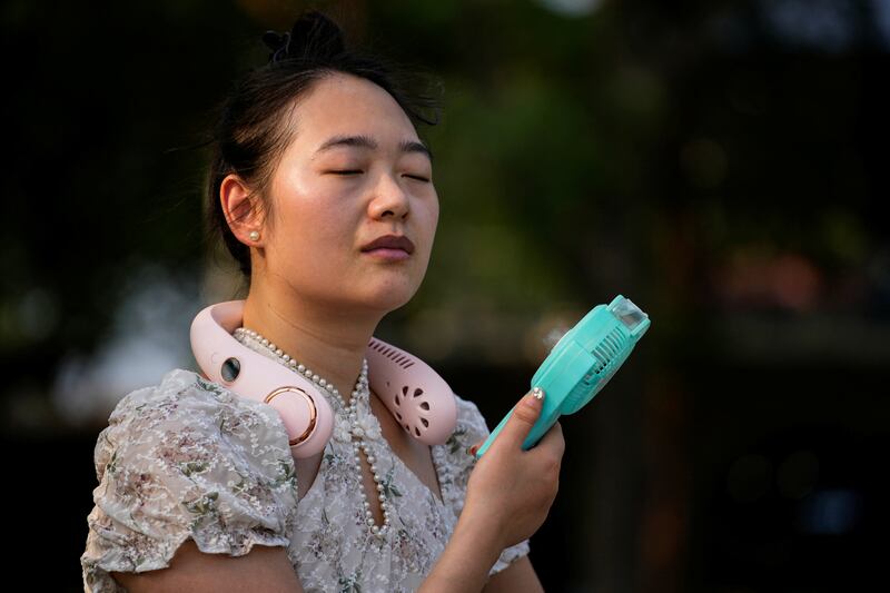 A woman uses a fan amid an alert for a heatwave in Shanghai. Reuters