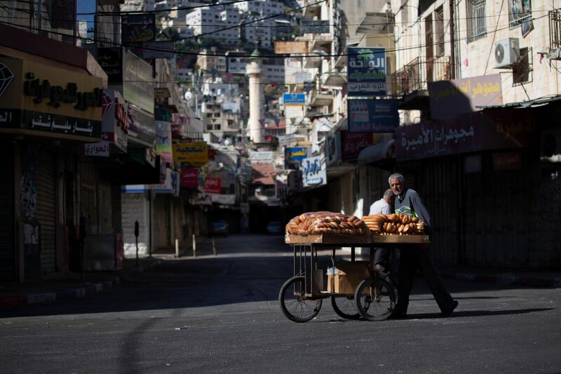 A Palestinian vendor pushes a cart loaded with bread during a general strike in the West Bank city of Nablus. AP Photo