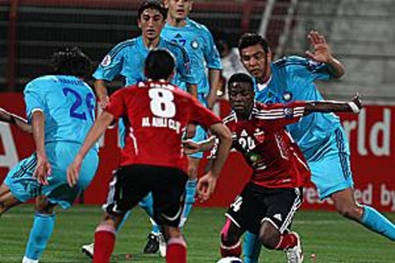 Ahli's Ismail al Hammadi, second right, is swamped by Pakhtakor players at the Al Rashid Stadium in Dubai on Tuesday night.