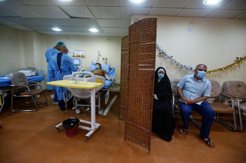 A couple who have recovered from the coronavirus wear protective face masks as they wait to donate blood plasma to help critically ill patients at Basra Teaching Hospital in Basra, Iraq. Reuters