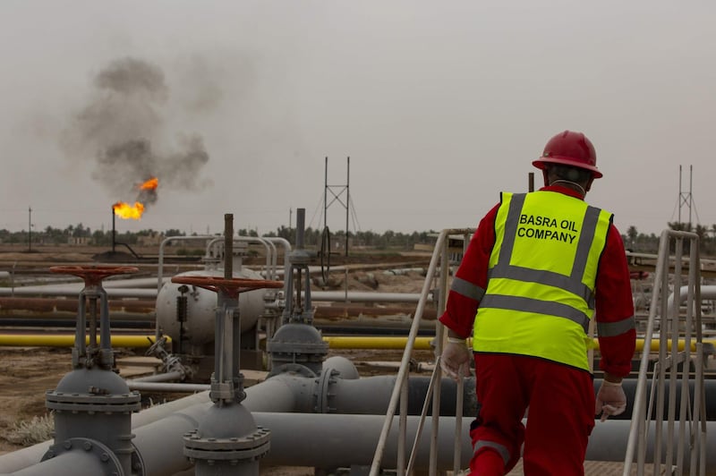 An employee watches the burning of excess hydrocarbons at the Nahr Bin Omar natural gas field, north of the southern Iraqi port of Basra on April 21, 2020.  / AFP / Hussein FALEH
