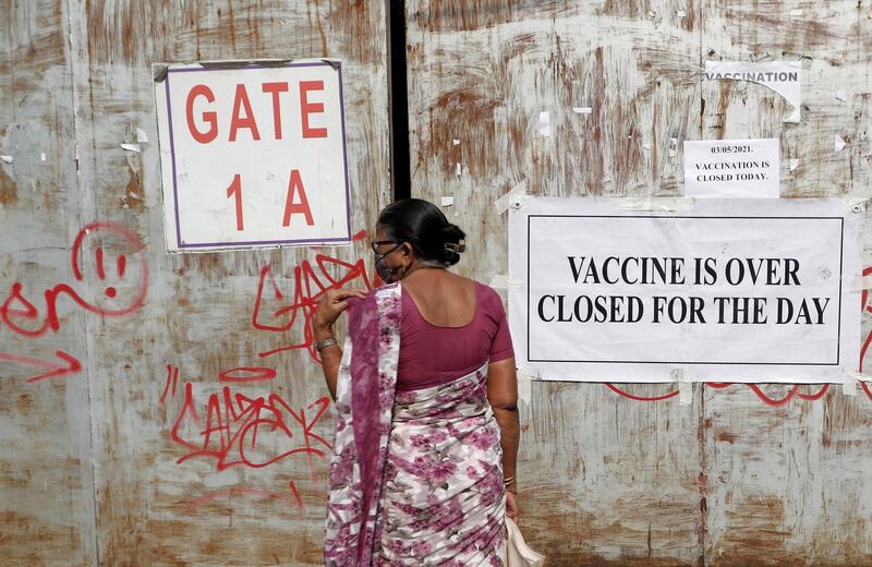 A woman, who came to receive a dose of a coronavirus disease vaccine, stands in front of a closed gate of a vaccination centre which was closed due to unavailability of the supply of COVID-19 vaccine, in Mumbai, India. Reuters