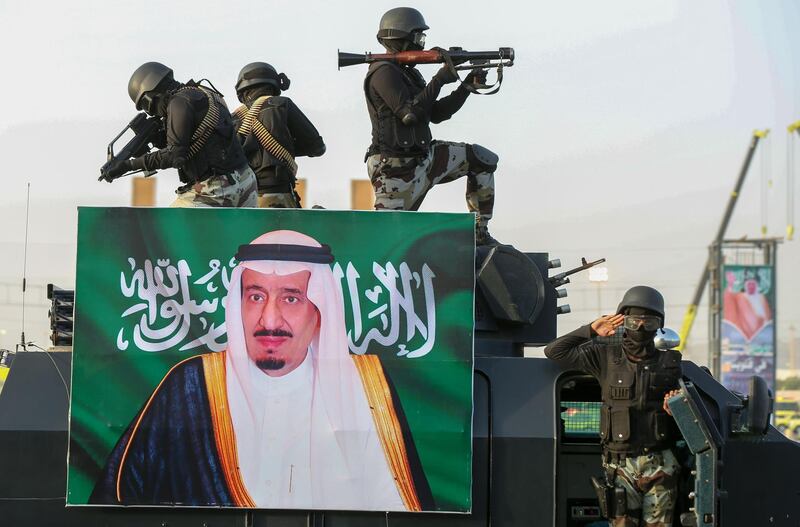 Saudi armed forces march during a parade in Saudi Arabia's holy city of Mecca on August 13, 2018, behind a portrait of the Saudi King Salman, ahead of the annual Hajj pilgrimage, - The hajj to Mecca, the most revered site in Islam, is a pilgrimage that Muslims must perform at least once in their lifetimes if they are able to do so. (Photo by BANDAR ALDANDANI / AFP)