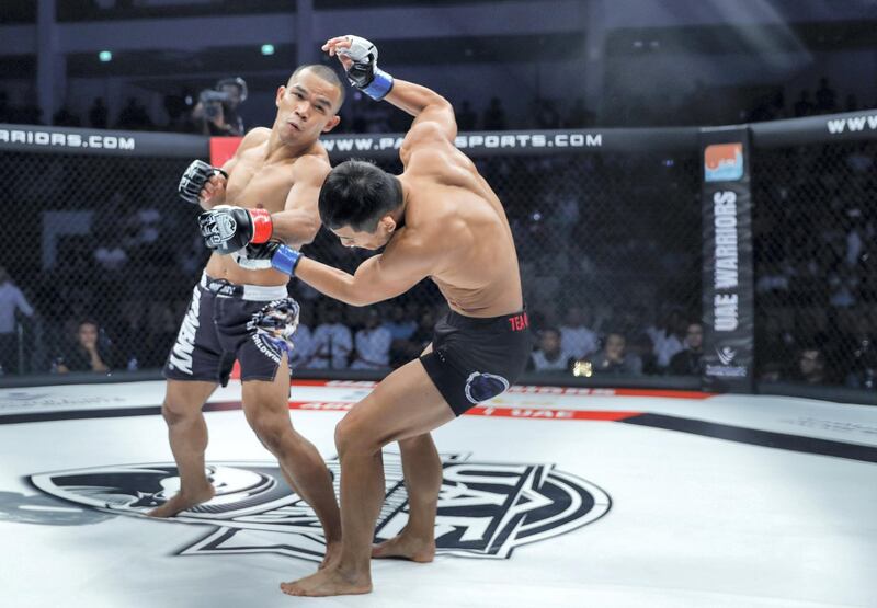 Abu Dhabi, United Arab Emirates, October 18, 2019.  UAE Warriors Fighting Championship at the Mubadala Arena.  (L-R)  Rolando Dy of the Philippines on the gives a left hook to Koran Lee Do-gyeom from South Korea.  Dy later on lost his featherweight title due to a swift KO by Lee Do-gyeom.
 Victor Besa/The National
Section:  SP
Reporter:  Amith Passela