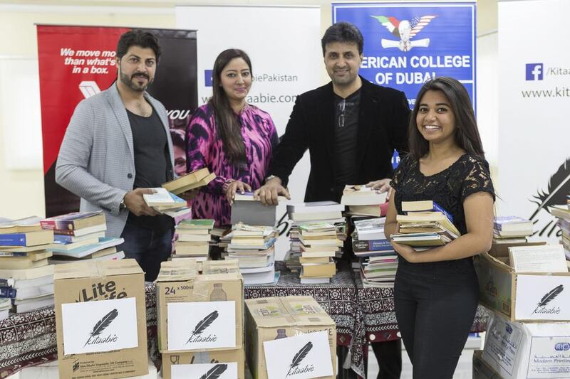 From right, student Ivanna Menezes, actor and director Asad Malik, Kitaabie founder Maha Khan and actor Zarrar Bin Saleem sort through and pack books at American College of Dubai. Antonie Robertson / The National