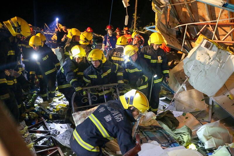 Emergency services personnel search through the wreckage of buildings destroyed by a reported tornado in Wuhan in central China's Hubei Province. Xinhua via AP