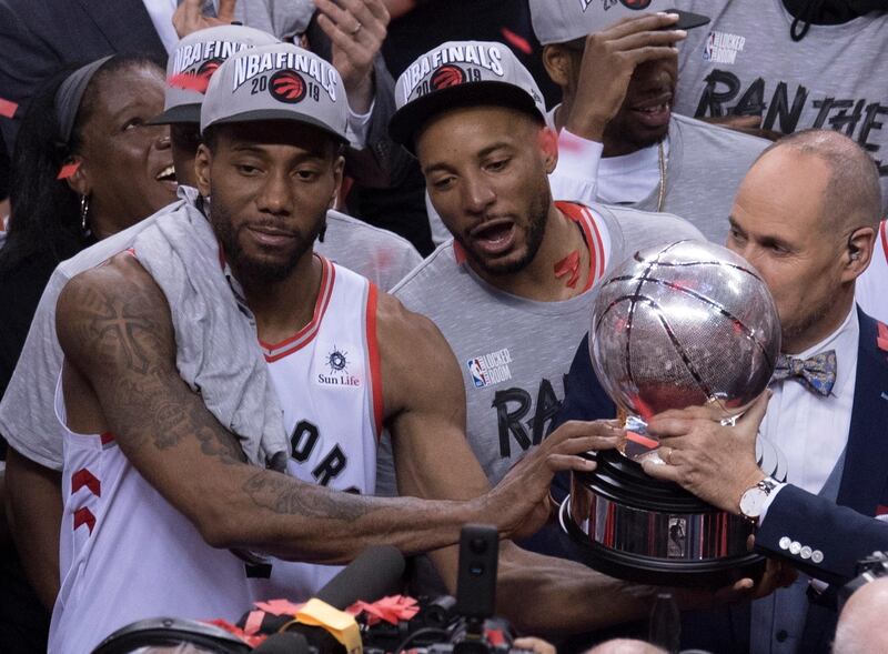 Toronto Raptors' Kawhi Leonard, left, hands teammate Norm Powell the trophy. AP Photo