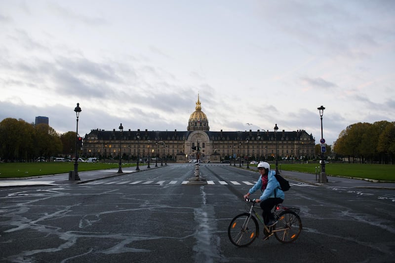 A cyclist rides across an empty road junction near Les Invalides in Paris. Bloomberg