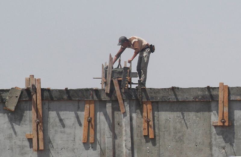 A carpenter works on a new wall that surrounds Cairo's airport in the Egyptian capital. Reuters