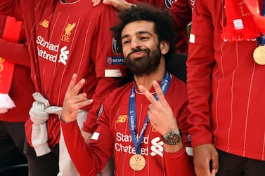 Liverpool's Egyptian midfielder Mohamed Salah gestures to the fans during an open-top bus parade around Liverpoo. AFP