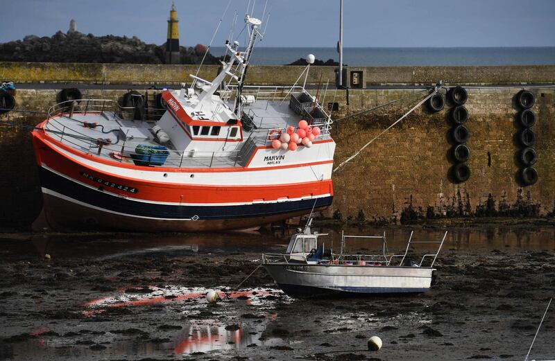 (FILES) In this file photo taken on November 13, 2020 A fishing boat sits on the sand at low tide alongside the quai in the port of Roscoff, western France.  The scramble for a post-Brexit trade deal headed into a new week on December 20, 2020 after talks were overshadowed by the coronavirus crisis and broke up with no breakthrough on fishing rights. Britain intends to assume control over its waters on January 1, but is ready to allow continued access to EU fishing fleets for a transitional period under new terms. EU fishermen fear that losing any access to the rich UK fishing waters will threaten their livelihoods.  / AFP / Fred TANNEAU

