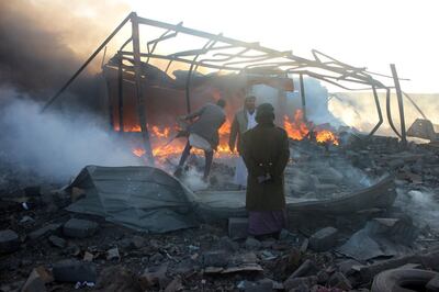 Smoke rises as Yemenis inspect the damage at the site of air strikes in the northwestern Huthi-held city of Saada, on January 6, 2018. / AFP PHOTO / STRINGER