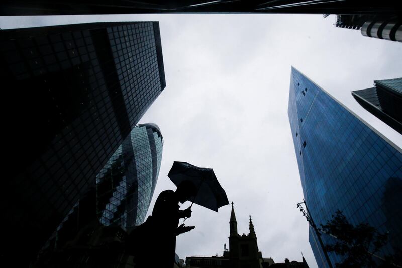 FILE PHOTO: A person walks through the financial district during rainy weather in London, Britain, September 23, 2018. REUTERS/Henry Nicholls/File Photo