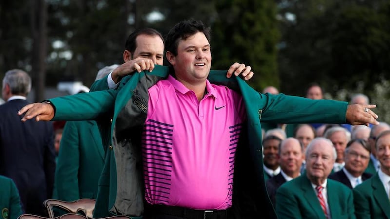 Sergio Garcia, left, the winner of the 2017 US Masters, puts the green jacket on this year's winner Patrick Reed. Jonathan Ernst / Reuters