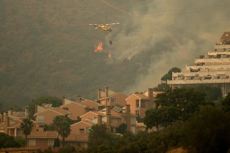 A firefighting helicopter flies over the blaze. AFP