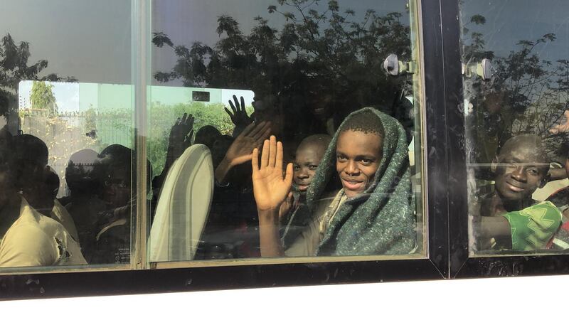 A boy waves from within a bus as children kidnapped by Boko Haram from the Government Science Secondary school, in Kankara, in northwestern Katsina State, Nigeria are seen returning after being freed.  AFP