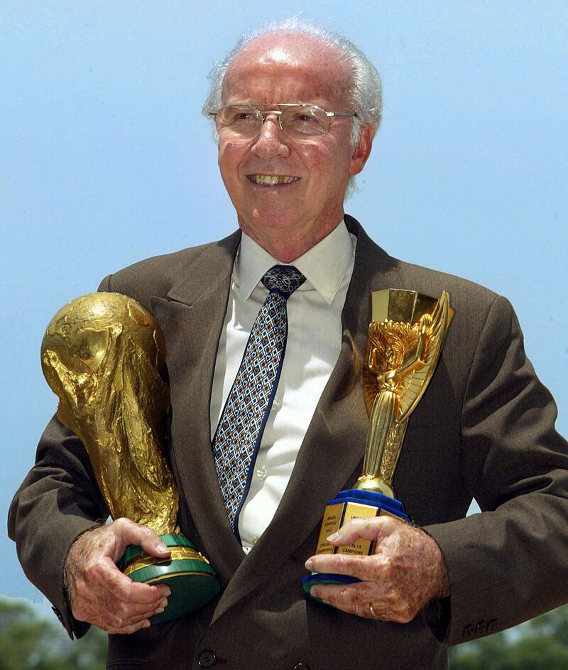 Four-time World Cup winner Mario Zagallo holds the Jules Rimet and Fifa trophies as he poses for photographers in Rio de Janeiro in March 2003. AFP