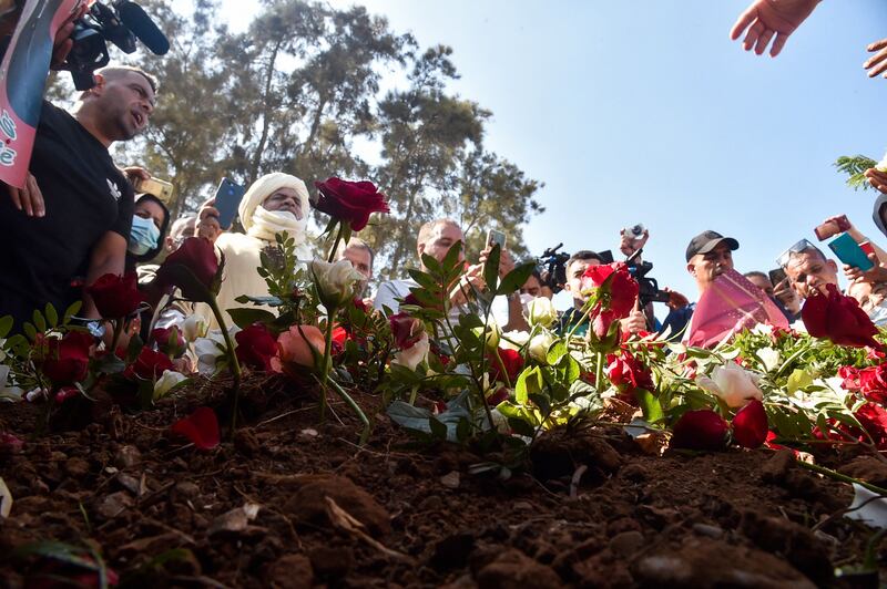 Algerians place roses on the tomb of former president Abdelaziz Bouteflika during his funeral at the El Alia cemetery in the capital Algiers . AFP