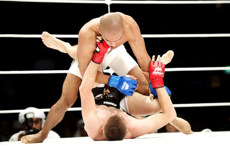 Emirati Ahmad Al Darmaki, top, put on a valiant effort against Artiyom Gorodynets in their featherweight fight at the Abu Dhabi Warriors Fighting Championship III held at Zayed Sports City , IPIC Arena on October 3, 2015. Vidhyaa for The National