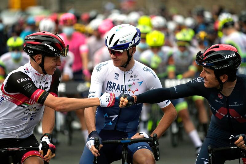 Slovenia's Tadej Pogacar, left, fist-bumps British rider Geraint Thomas.