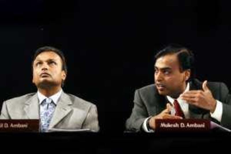 File photo of Chairman of Reliance Industries Ltd Mukesh Ambani speaking as his brother and vice-chairman Anil Ambani watches in Bombay.   The Chairman of India's Reliance Industries Ltd, Mukesh Ambani (R), speaks as his brother and vice-chairman of the company Anil Ambani watches during the company's Annual General Meeting (AGM) in Bombay in this June 24, 2004 file photo. Two brothers at the helm of India's largest private conglomerate, Reliance, have settled a seven-month old dispute that has transfixed the country, carving up their father's legacy in a deal announced by their mother. The Ambani brothers will split the management of the business empire established by their late father, dividing control of a group with a vast retail shareholder base and