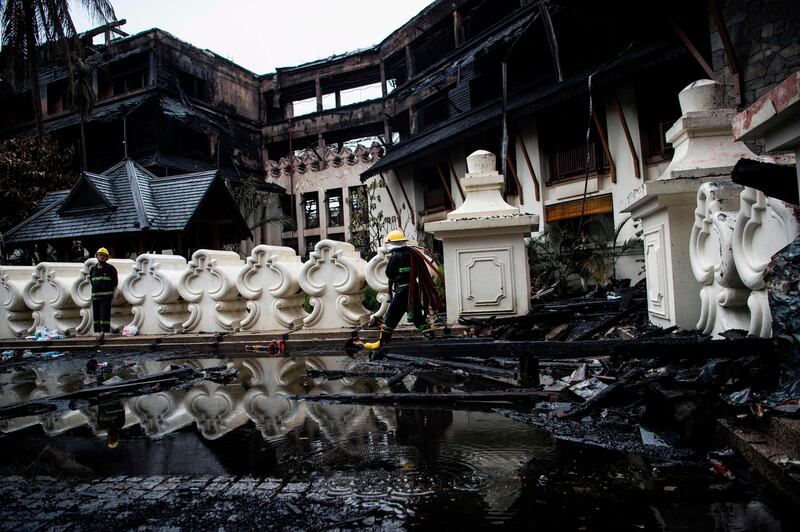 Firefighters work at the scene after a fire at Kandawgyi Palace hotel in Yangon on October 19, 2017.
One person died in a pre-dawn blaze on October 19 that tore through a teakwood hotel in Yangon popular with foreign visitors to Myanmar's main city. / AFP PHOTO / YE AUNG THU
