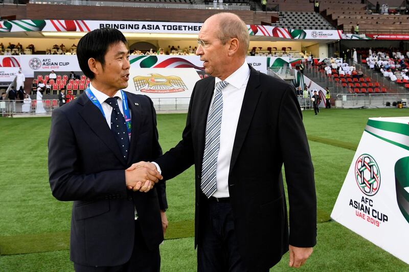 Japan's coach Hajime Moriyasu, left, shakes hands with Oman's coach Pim Verbeek. AFP