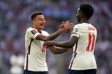 England's Jesse Lingard (left) celebrates with Bukayo Saka after scoring their side's third goal of the game during the 2022 FIFA World Cup Qualifying match at Wembley Stadium, London. Picture date: Sunday September 5, 2021.