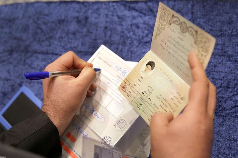 A poll worker checks the ID of Iran's Supreme Leader Ayatollah Ali Khamenei who has arrived to cast his vote at a polling station during parliamentary elections in Tehran, Iran. Reuters
