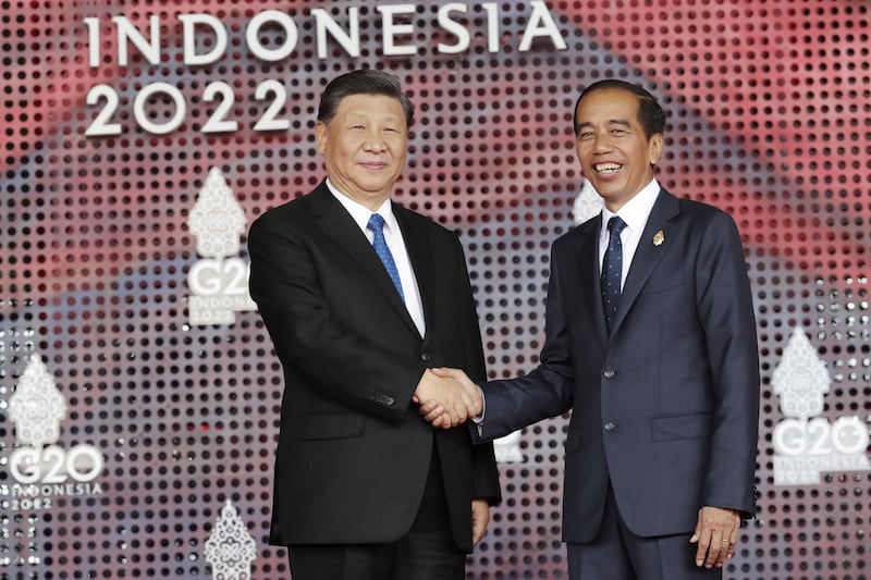 The Chinese leader shakes hands with President Joko Widodo, right, of host nation Indonesia. AP